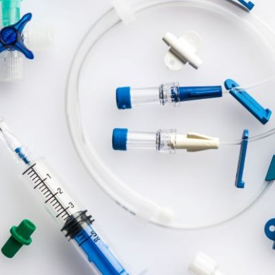 plastic tubing with blue clips, taps and end pieces and a syringe with needs attached 